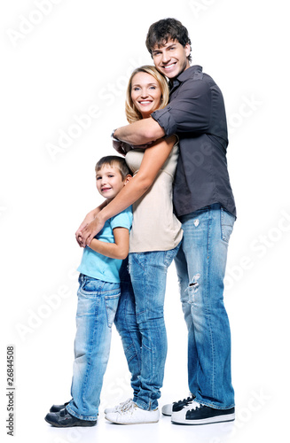 Photo: Full portrait of happy family with child standing on white Full portrait of happy family with child standing on white