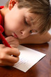 Boy writing note letter to santa