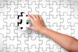 Child's hand, inserting piece of jigsaw puzzle into the hole