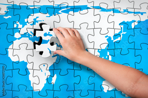 Illustration: Child's hand inserting piece of jigsaw puzzle into the map hole Child's hand inserting piece of jigsaw puzzle into the map hole
