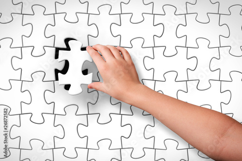 Illustration: Child's hand, inserting piece of jigsaw puzzle into the hole Child's hand, inserting piece of jigsaw puzzle into the hole