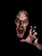 Evil zombie face coming at ya from the dark