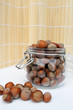 vaso in vetro con nocciole e fondo in bamboo