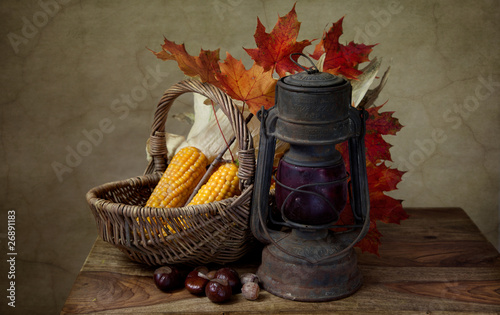 Photo: Herbstliches Stilleben mit Petroleumlampe und Mais in Weidenkorb Herbstliches Stilleben mit Petroleumlampe und Mais in Weidenkorb