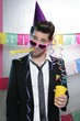 Blowing noisemaker suit party funny young man