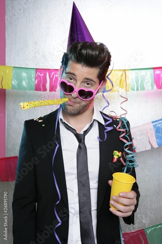 Photo: Blowing noisemaker suit party funny young man Blowing noisemaker suit party funny young man
