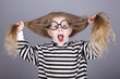 Young shouting child in glasses and striped knitted jacket.