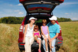 Family of four near their car on vacation