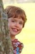 Child peeking from behind a tree Child peeking from behind a tree