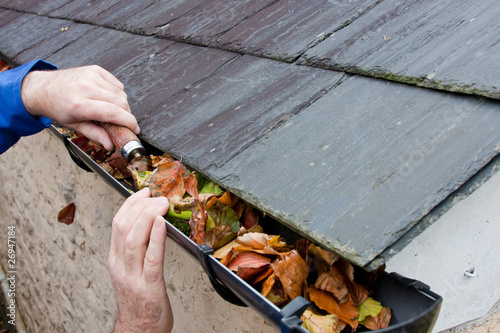 Foto: Workman Clearing Autumn Leaves from Gutter Workman Clearing Autumn Leaves from Gutter