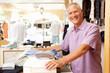 Photo: Male Sales Assistant At Checkout Of Clothing Store Male Sales Assistant At Checkout Of Clothing Store