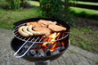 Grill mit Grillfleisch und Bratwurst im Garten