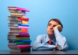 Photo: man at the table looking at a stack of colored books man at the table looking at a stack of colored books