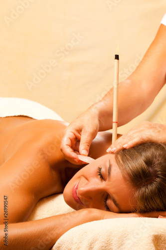 Foto: Woman with ear candles and gem massage Woman with ear candles and gem massage