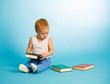 Photo: Two years old cute boy chooses what to read from three books Two years old cute boy chooses what to read from three books