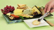 Cheese platter with various cheeses and fruits being served