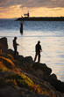 Two fishermen on rocks at sunset in Fremantle, Australia.