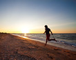 Teen boy runs at the beach on beautiful summer sunset Teen boy runs at the beach on beautiful summer sunset