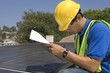 Photo: Maintenance worker makes notes with solar array on rooftop, Los Angeles, California Maintenance worker makes notes with solar array on rooftop, Los Angeles, California