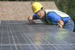 Photo: Maintenance worker measures solar array on rooftop, Los Angeles, California Maintenance worker measures solar array on rooftop, Los Angeles, California