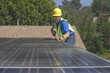 Photo: Maintenance worker measures solar array on rooftop, Los Angeles, California Maintenance worker measures solar array on rooftop, Los Angeles, California