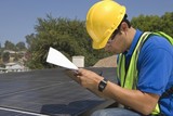 Photo: Maintenance worker makes notes with solar array on rooftop, Los Angeles, California Maintenance worker makes notes with solar array on rooftop, Los Angeles, California
