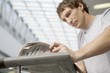 Young man stands reading newspaper in new shopping centre, Voronezh