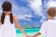 Children holding hands by sea