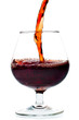 Red wine being served into a glass cup on a white background