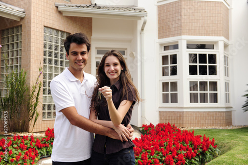 Photo: Happy homeowners infront of new house Happy homeowners infront of new house