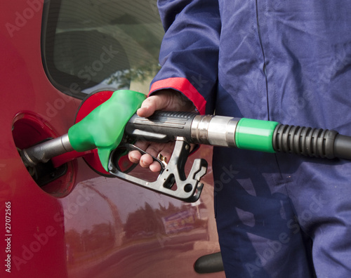 Photo: Gas Station Worker Refilling Car at Service Station Gas Station Worker Refilling Car at Service Station