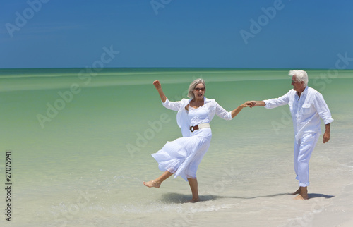 Photo: Happy Senior Couple Dancing Holding Hands on A Tropical Beach Happy Senior Couple Dancing Holding Hands on A Tropical Beach