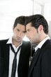 Handsome narcissistic young man looking in a mirror
