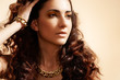 Glamour model with shiny gold jewelry, volume hair