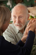 Senior couple at home holding hands focusing on man