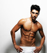 Photo: Sexy muscular man posing against white background Sexy muscular man posing against white background