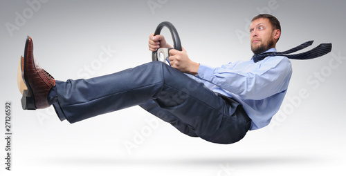 Foto: Businessman driver in a tie with a wheel Businessman driver in a tie with a wheel
