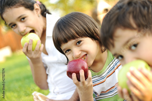 Photo: Small group of children eating apples together, Small group of children eating apples together,