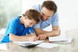 Father helping his little son in schoolwork