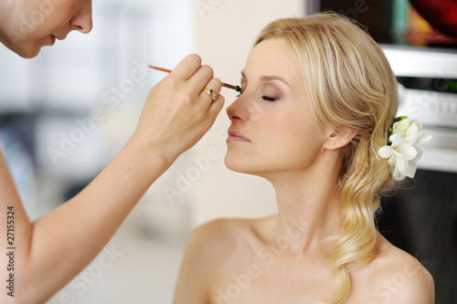 Foto: Young beautiful bride applying wedding make-up Young beautiful bride applying wedding make-up