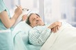 Nurse taking notes of old patient