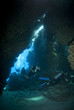 Scuba divers exploring the inside of an underwater cave.