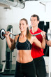 Personal Trainer und Frau im Fitnessstudio