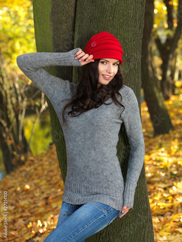 Photo: Beautiful woman spending time in park during autumn season Beautiful woman spending time in park during autumn season