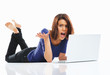 Angry female student lying on floor while using against white