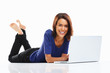 Teen girl lying on floor doing homework on laptop against white