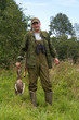 Hunter with duck in hand on a madow.