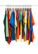 Variety of multicolored shirts on wooden hangers Variety of multicolored shirts on wooden hangers