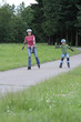 Happy family learning to ride on rollerblades