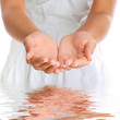 Foto: Hands cupped together against white dress with water reflection. Hands cupped together against white dress with water reflection.